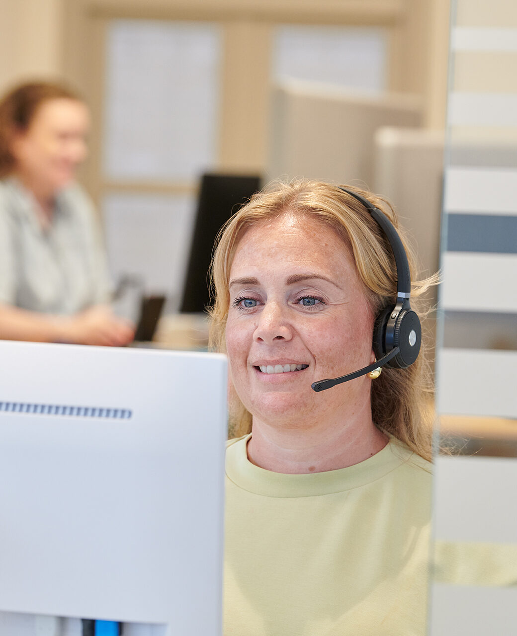 Een assistente met headset beantwoordt de telefoon