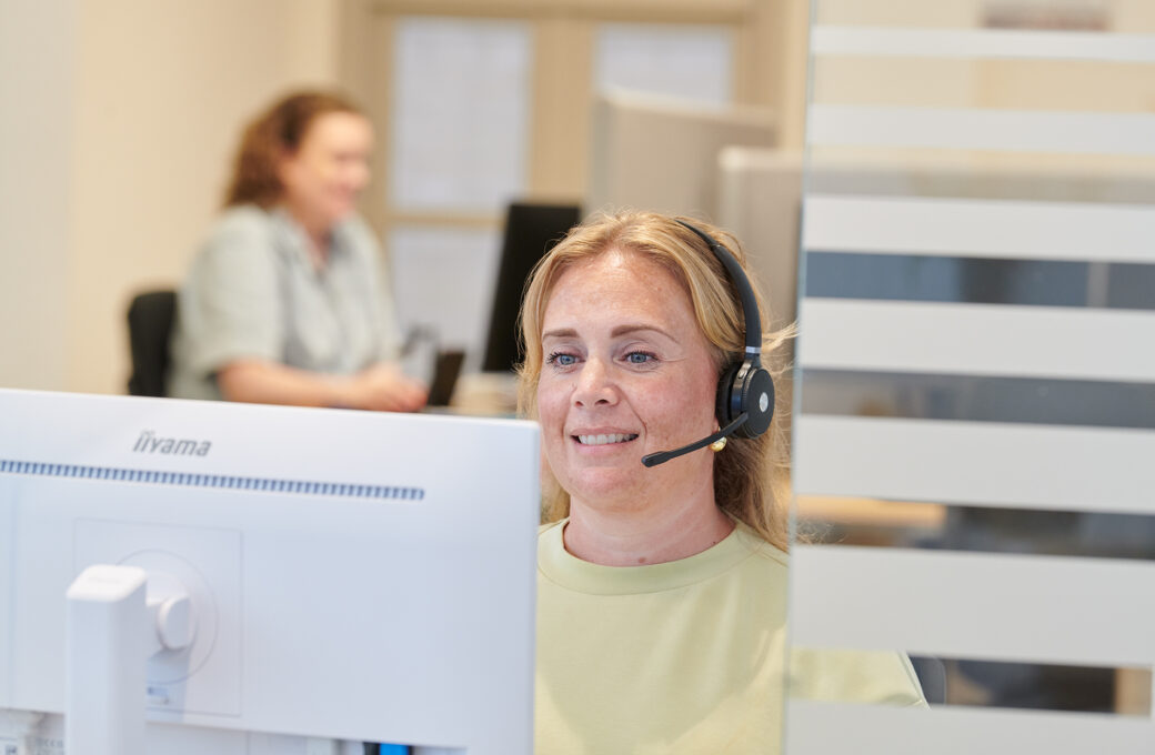 Een assistente met headset beantwoordt de telefoon