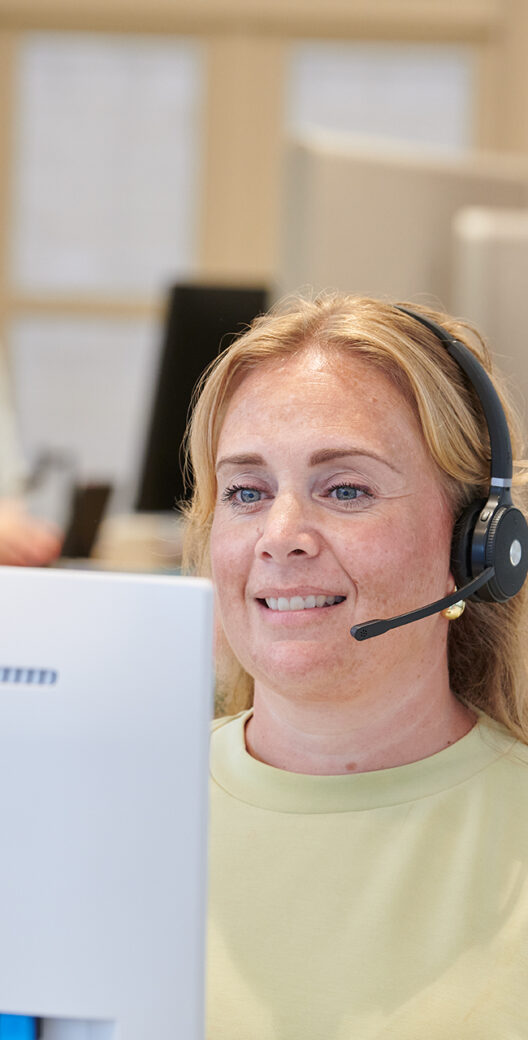 Een assistente met headset beantwoordt de telefoon