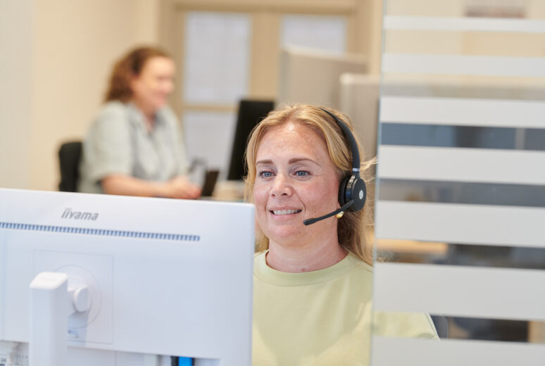 Een assistente met headset beantwoordt de telefoon