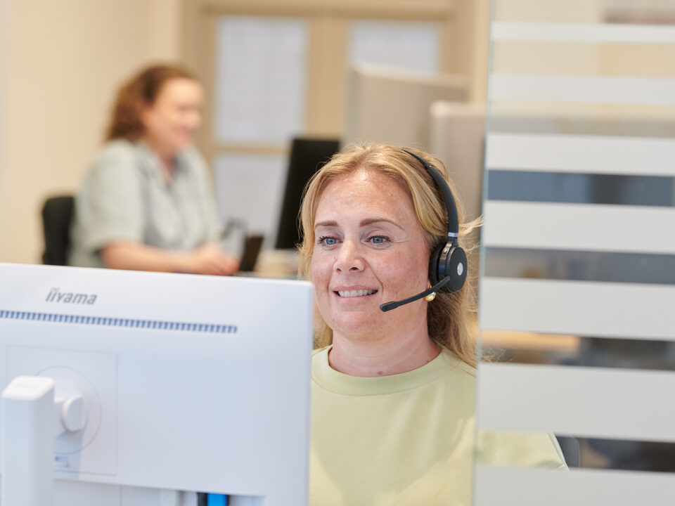 Een assistente met headset beantwoordt de telefoon